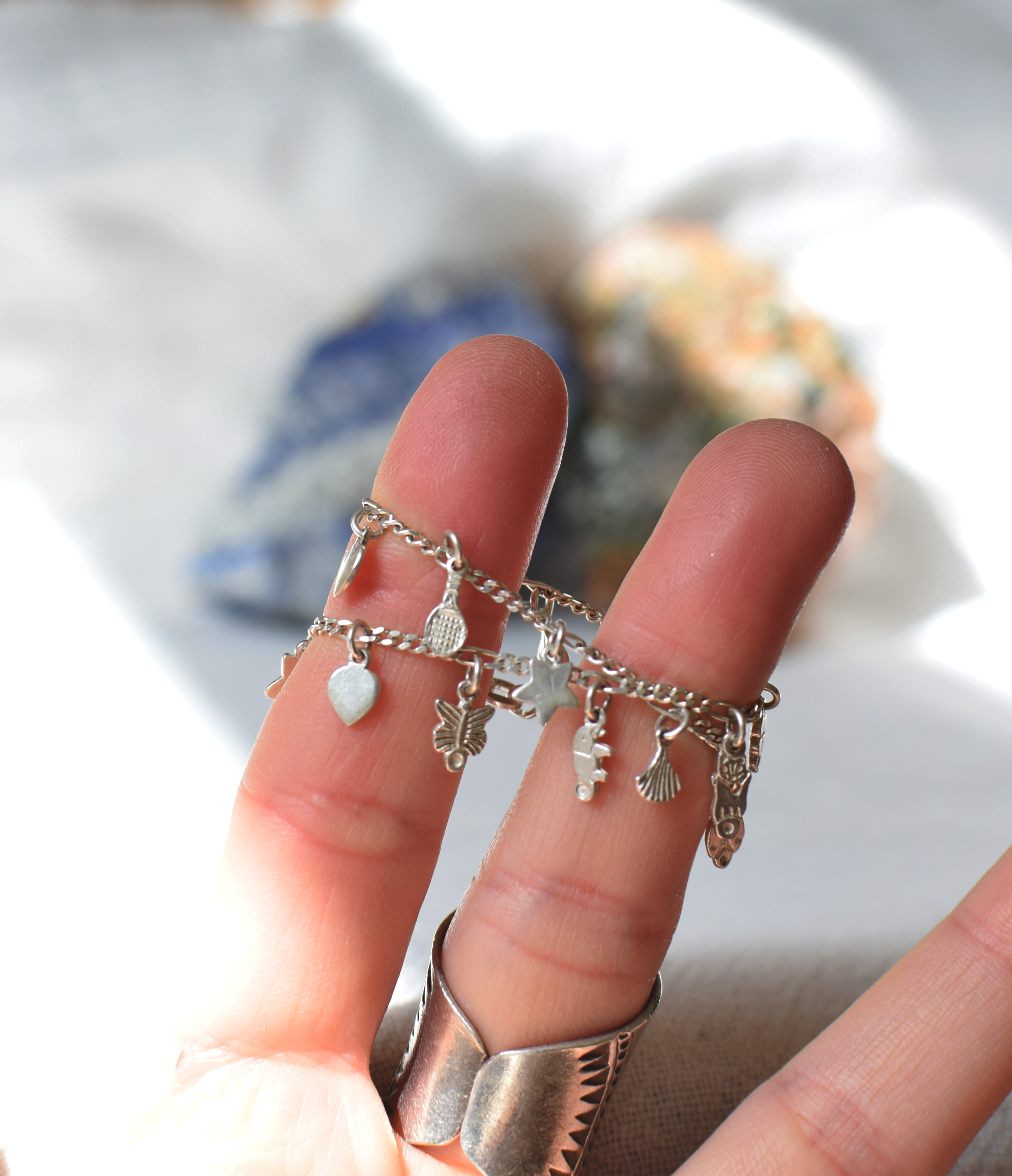 Close-up of a sterling silver bracelet with charms on a blurred background