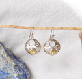 Silver earrings with yellow gemstones on a white background